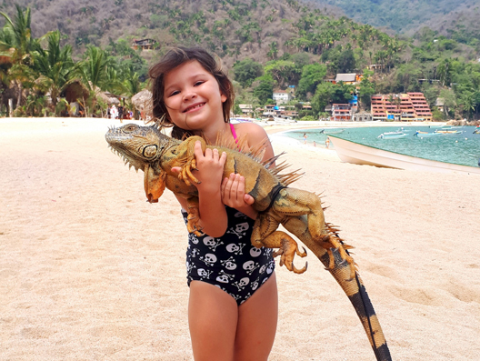 little girl with an iguana in mexico